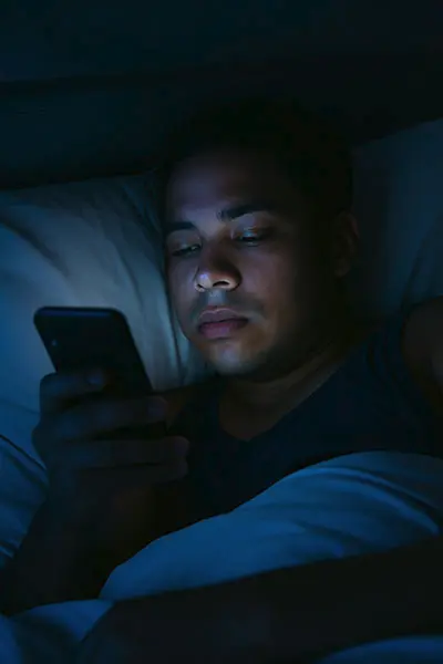 Person using phone before bed, keyword: blue light sleep disruption